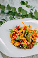 Vegetarian tomato, olives pepper salad in a white plate on a marble table, healthy food