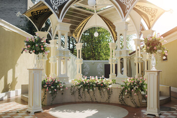 wedding arch in a restaurant with tulips. beautiful white columns and roof.