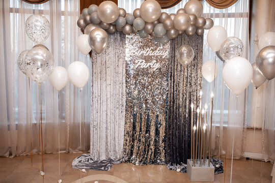 large birthday photo zone for an adult with shiny balloons. sequins and silk fabric.