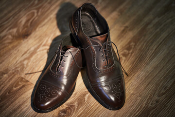 classic brown patent leather shoes with heels on a wooden parquet. groom's morning.
