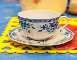 Cup saucer for drinks on color napkin, on the table