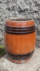 Fototapeta premium Brown ceramic barrel on the background of gray wall