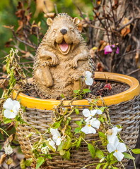 Gypsum statuette of a hedgehog on the background of autumn leaves