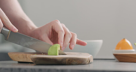 Man slicing ripe avocado on kitchen countertop side view