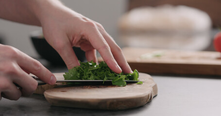 man takes chopped parsley on olive board side view