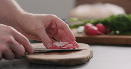 man take fresh sliced radish from olive board side view