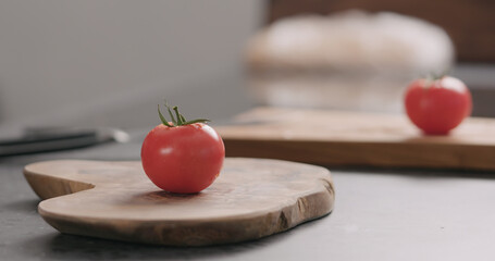 fresh red tomato on olive board side view