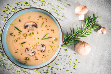 Delicious mushroom cream soup with champignons on the gray table