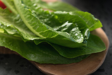 fresh romaine lettuce leaves on wood board