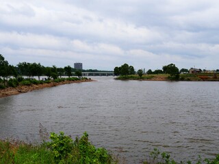Riverside view of Tulsa City bridge with the Arkansas River flowing into a water inlet.