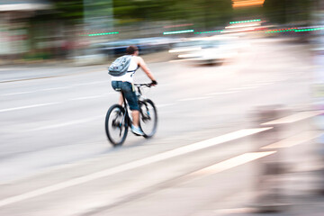 Obraz na płótnie Canvas Blurry panning shot of young man speeding on a bike