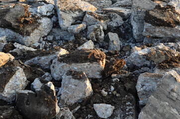 Broken pieces of asphalt at a construction site. Recycling and reuse crushed concrete rubble, asphalt, building material, blocks. Crushed сoncrete Background. Road repair, replacement of old pavement