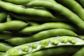 Photography of a bunch of broad bean pods and broad beans in open pod for food background