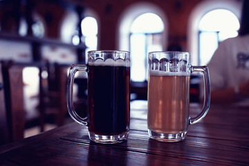 two beer mugs in a Czech beer restaurant / light and dark beer in large mugs traditional Prague pub