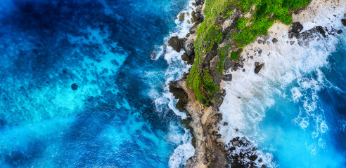 Waves and rocks as a background from top view. Blue water background from top view. Summer seascape...