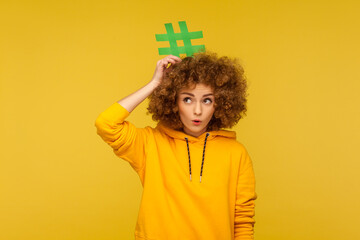 Popular blog posts, trendy content. Portrait of surprised curly-haired woman in urban style hoodie...