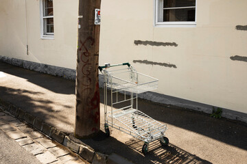 Abandoned shopping cart on sidewalk.