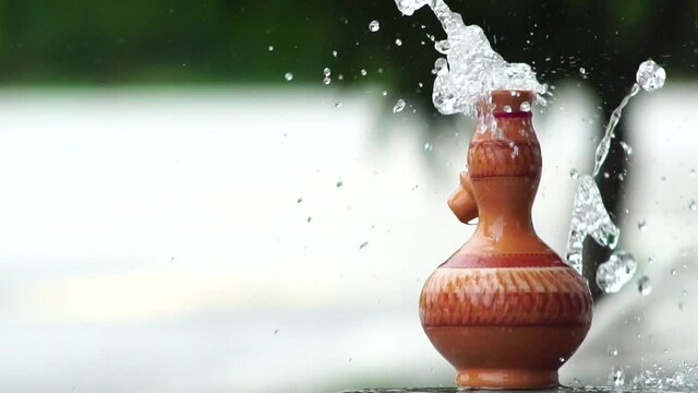 Handmade traditional craft known as 'labu sayong' pouring with water. Used as gift or souvenir found in Perak,Malaysia. Clay pottery arts.