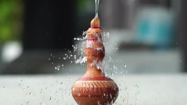 Handmade traditional craft known as 'labu sayong' pouring with water. Used as gift or souvenir found in Perak,Malaysia. Clay pottery arts.