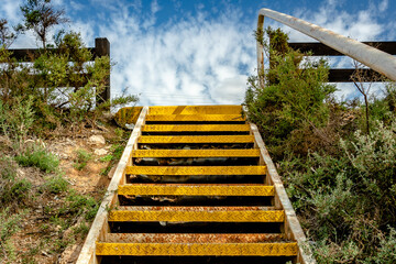 Up top view at the yellow metal stairs leading to the top