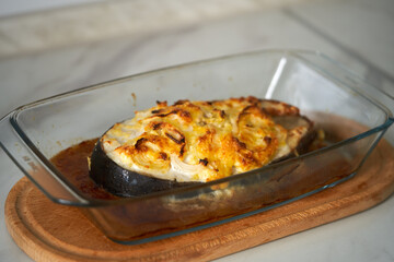 baked fish with cheese lies on a transparent dish