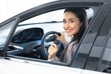 Smiling Woman Showing Key Sitting In Driver's Seat