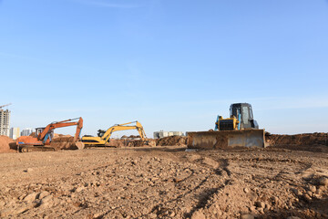 Obraz premium Excavators and dozer digs ground at a construction site for installing sewer storm pipes. Backhoe for digging pipeline ditch. Commercial and Public Civil Work Contracting, trenching, tamps soil