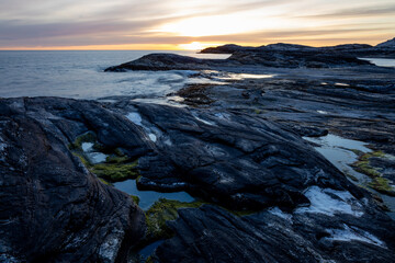 Sunset light on smoth rocs by the sea in Norway