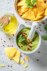 Homemade guacamole with tortilla, red pepper and coriander