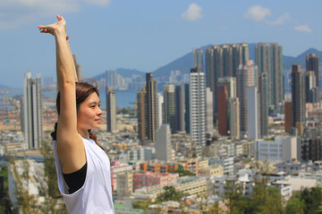 Fototapeta na wymiar sporty woman take exercise in front of the skyline of city