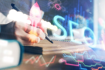 Multi exposure of woman's hands making notes with SEO icon. Concept of Search engine optimization