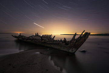 Beautiful star trails with a shipwreck Raketa on the shore of Baltic Sea near Loksa, Estonia....