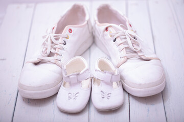 Daddy's baby's sneakers, on white wooden background, fathers day concept.