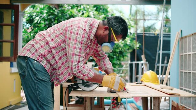 Carpenter or craftsman works by using machines to work on the construction site. Professional carpentry career. Lifestyle of the New Normal people work at home, repairing the house