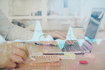 Multi exposure of stock market graph with man working on laptop on background. Concept of financial analysis.