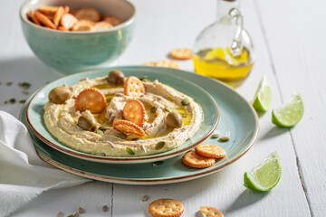 Fresh hummus with crackers and pumpkin seeds