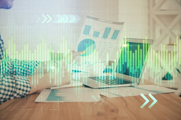 Multi exposure of financial graph with man works in office on background. Concept of analysis.