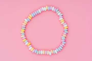 Tuinposter sweets Beads and bracelets candy on a pink background © luchschenF