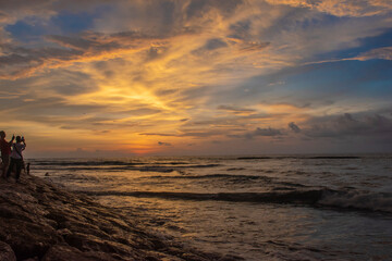 Fototapeta premium People are trying to take the picture of beautiful sunset through the horizon from the seashore in Bali