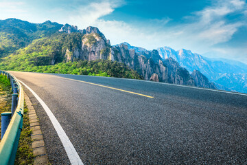 Empty asphalt road and mountain natural scenery on a sunny day.