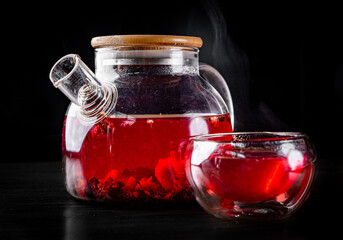tea pot and Cup of fresh sweet berry tea on black background