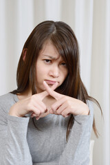 バツ印を出す若い女性