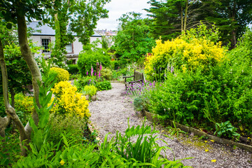 Colourful Glebe garden summer flower garden with a path under archway