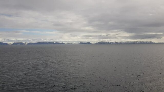 mighty sea and snowy mountain view sailing a ship in Finnmark, northern Norway