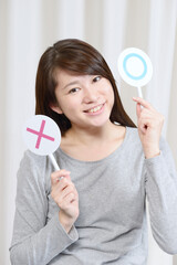 マルバツのプレートを出す女性