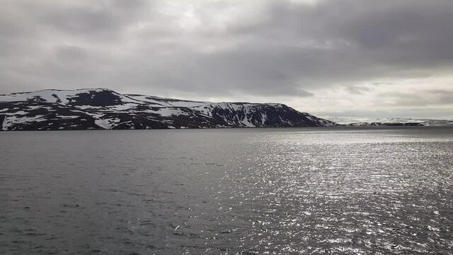 mighty sea and snowy mountain view sailing a ship in Finnmark, northern Norway