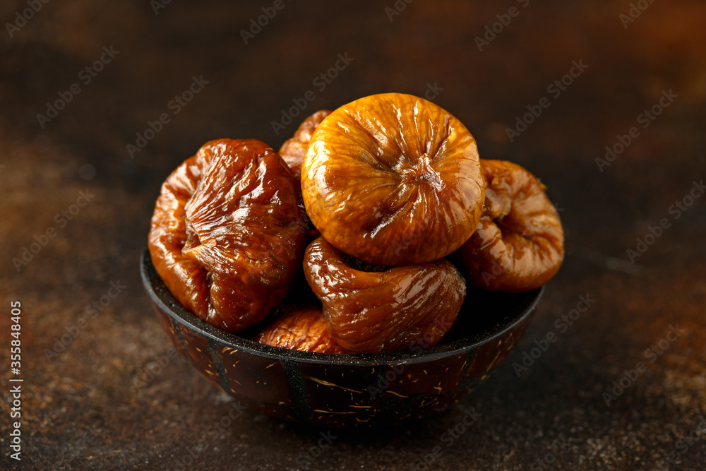 Wall mural sun dried soft sweet figs fruits in coconut bowl