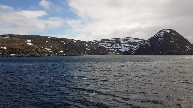 mighty sea and snowy mountain view sailing a ship in Finnmark, northern Norway