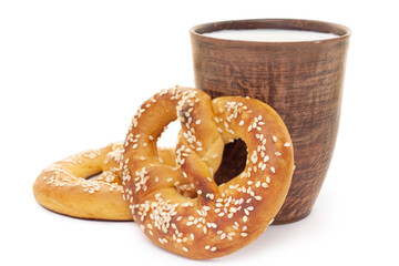 Tasty fresh just from oven crispy two Brezel pretzel with brown ceramic glass of milk isolated