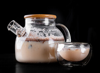 tea pot and Cup of masala tea on black background